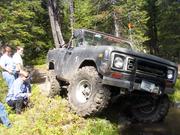 Tom shows off by driving over the big rock.. Don Gordon spots
